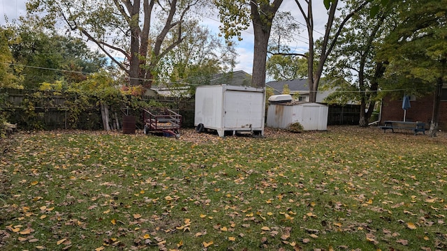 view of yard with a storage unit, an outdoor structure, and fence