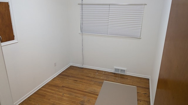 empty room with visible vents, baseboards, and wood finished floors