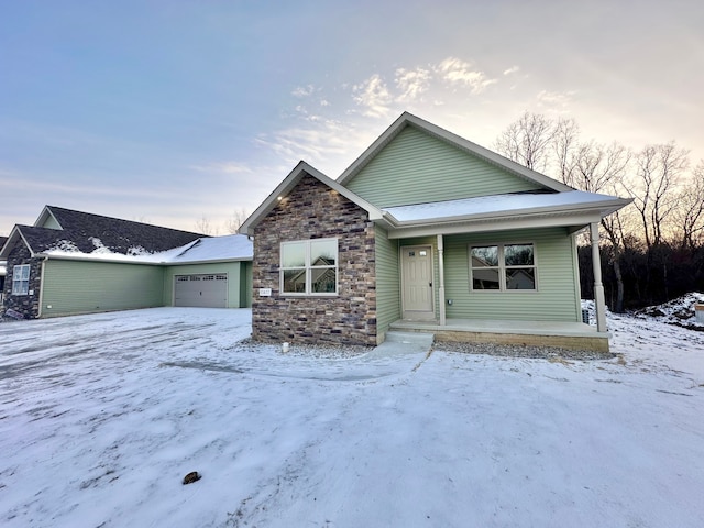 view of front of house featuring stone siding, covered porch, and an attached garage