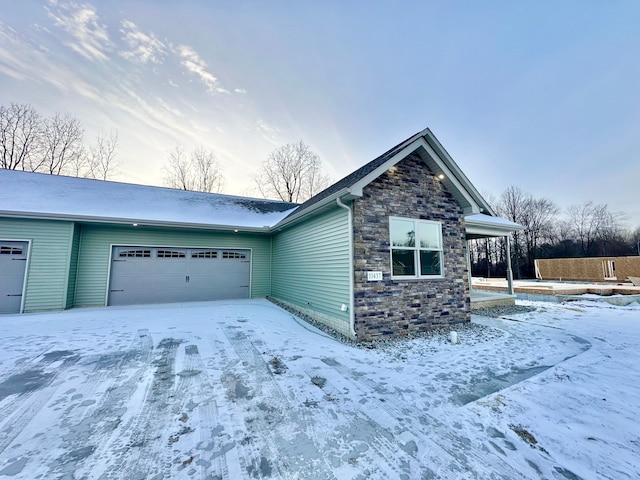 view of front of home featuring stone siding and an attached garage