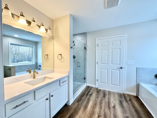 full bathroom featuring wood finished floors, vanity, visible vents, a shower stall, and a bath