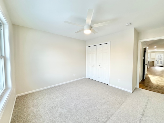 unfurnished bedroom featuring carpet, baseboards, and a closet