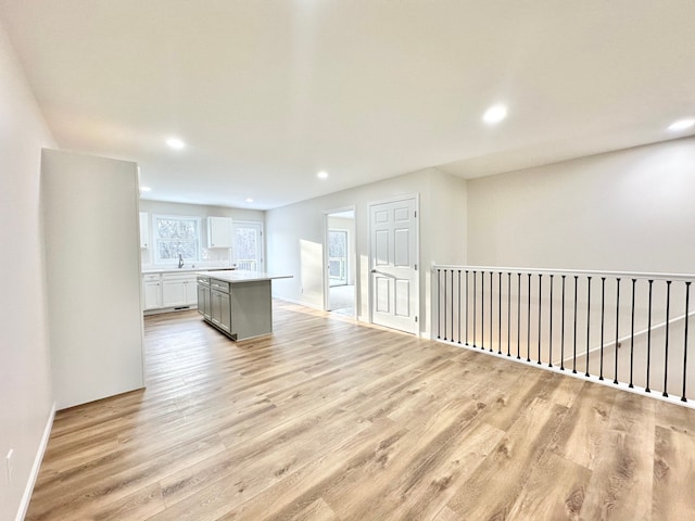 empty room featuring light wood-type flooring, baseboards, and recessed lighting