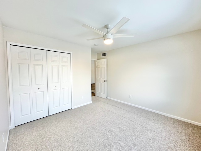 unfurnished bedroom with ceiling fan, light carpet, visible vents, baseboards, and a closet