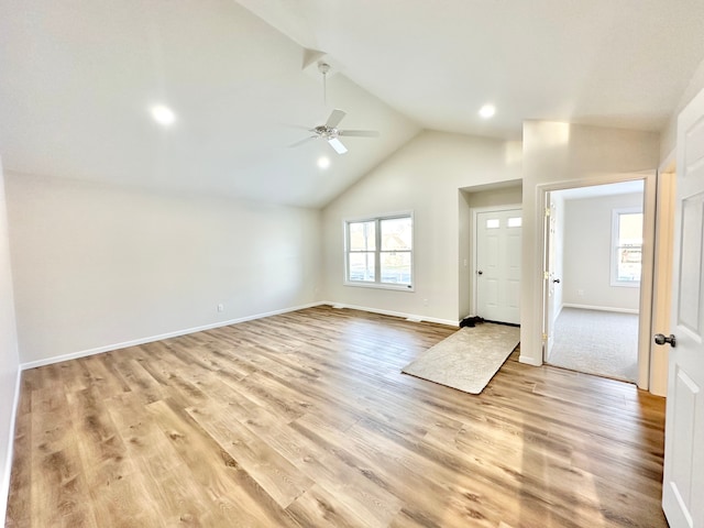 entryway with light wood finished floors, ceiling fan, baseboards, and high vaulted ceiling