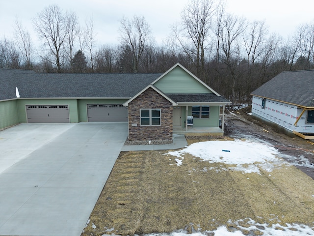 view of front of home featuring concrete driveway, stone siding, roof with shingles, an attached garage, and covered porch