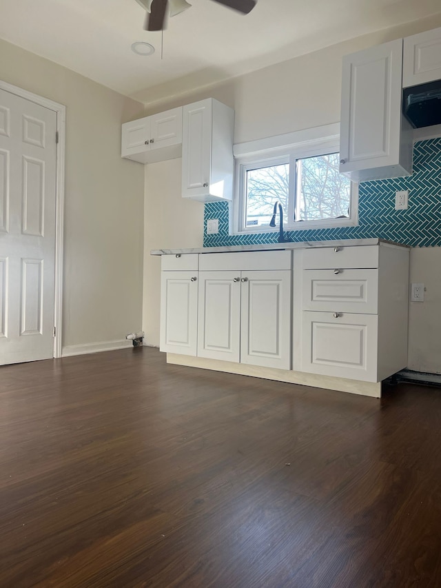 kitchen featuring backsplash, ceiling fan, white cabinets, and dark hardwood / wood-style floors