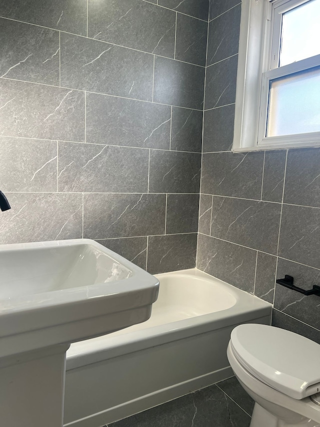 bathroom featuring toilet and tile walls