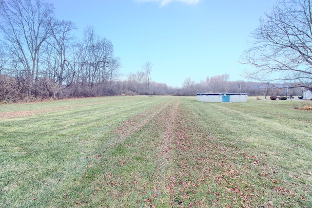 view of yard featuring a rural view and a covered pool