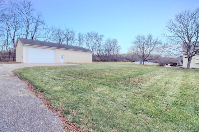 view of yard with a garage and an outbuilding