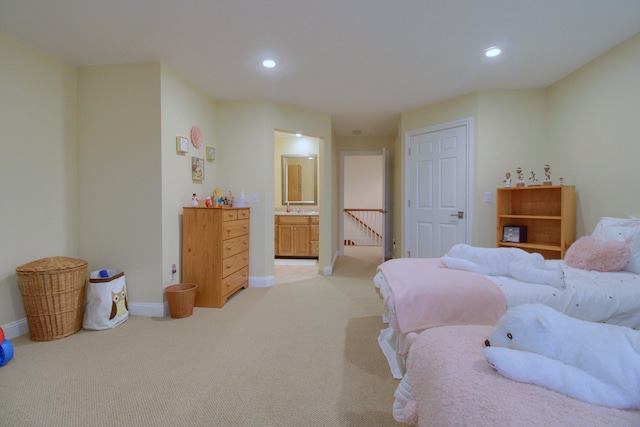 carpeted bedroom with ensuite bathroom and sink