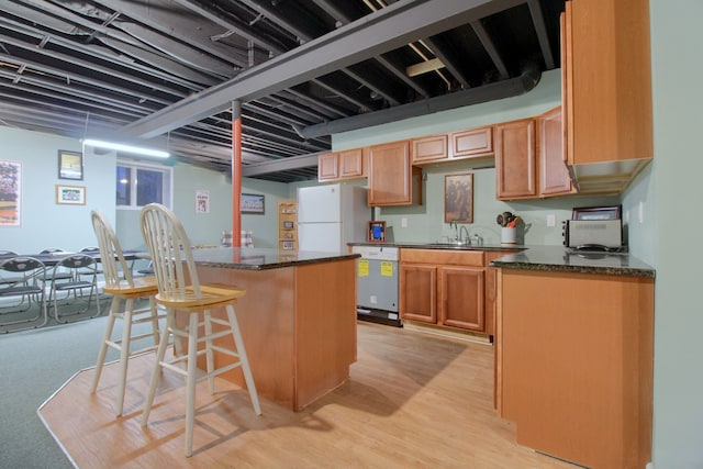 kitchen with a kitchen breakfast bar, light hardwood / wood-style flooring, dishwasher, a center island, and white fridge