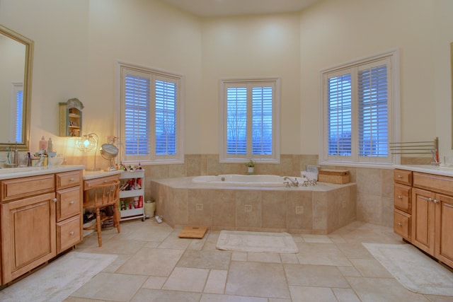 bathroom featuring vanity, a high ceiling, and tiled bath