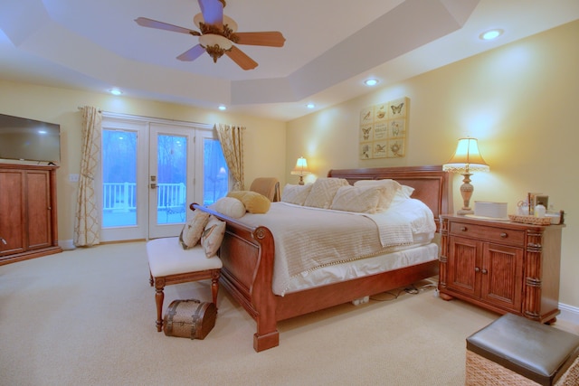 bedroom featuring a raised ceiling, access to exterior, ceiling fan, and light colored carpet