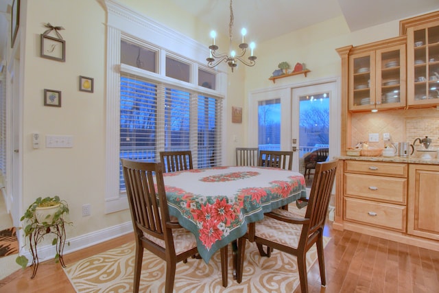 dining space featuring light wood-type flooring and an inviting chandelier