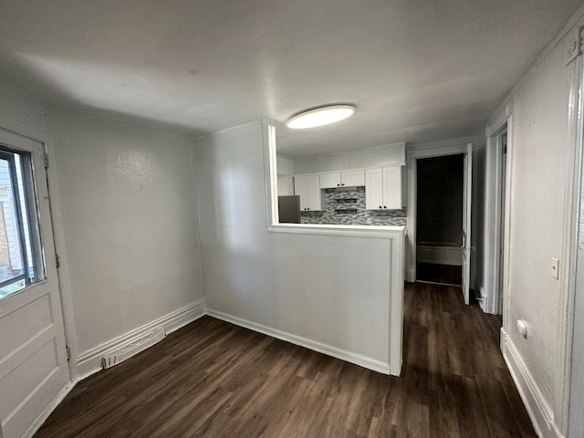 kitchen featuring white cabinets, decorative backsplash, dark hardwood / wood-style flooring, and stainless steel fridge