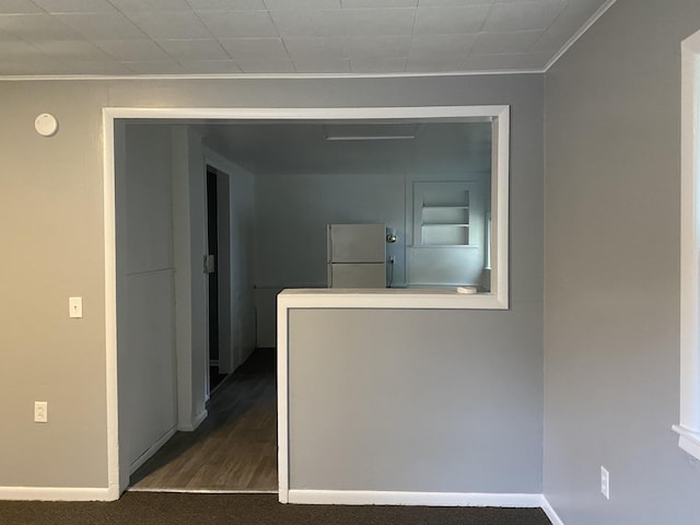 corridor featuring dark carpet and crown molding