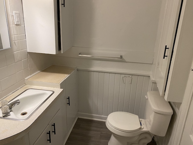 bathroom featuring backsplash, hardwood / wood-style floors, vanity, and toilet