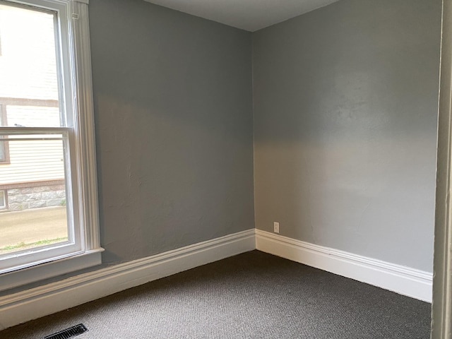 carpeted spare room featuring plenty of natural light