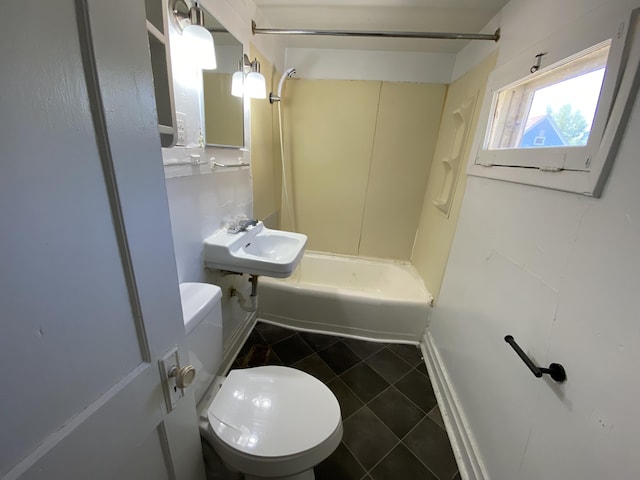 full bathroom featuring tub / shower combination, toilet, sink, and tile walls