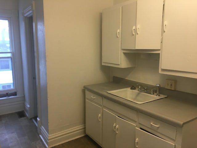 kitchen featuring plenty of natural light, white cabinets, and sink