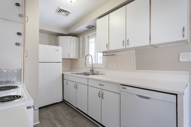 kitchen with white appliances, white cabinets, sink, dark hardwood / wood-style floors, and tasteful backsplash