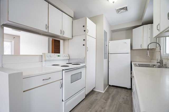 kitchen featuring white appliances, sink, light wood-type flooring, tasteful backsplash, and white cabinetry