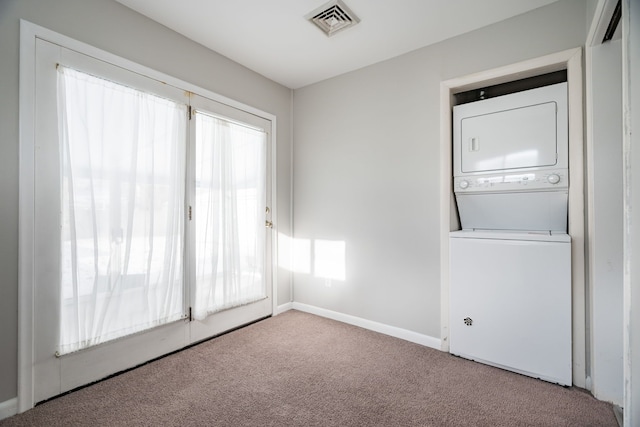 washroom featuring light colored carpet and stacked washer / drying machine