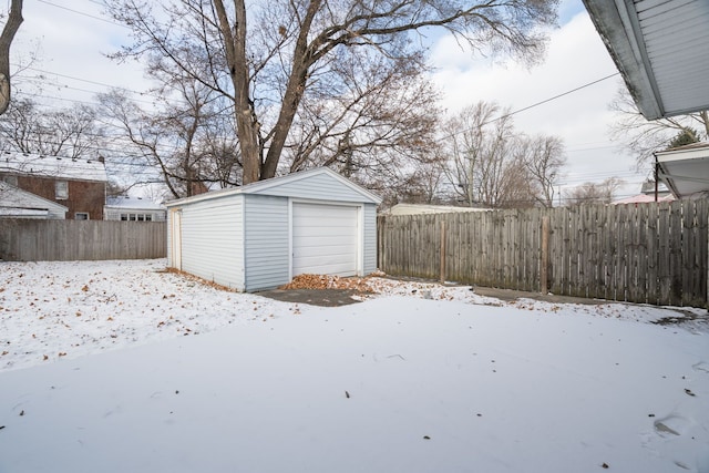 yard covered in snow with an outbuilding and a garage