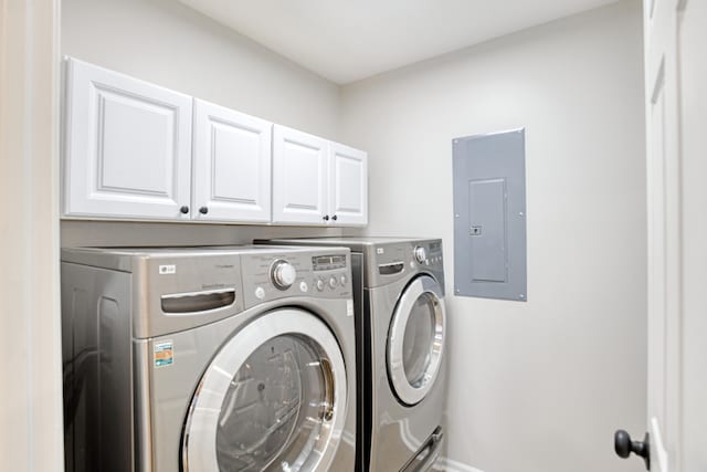 washroom with cabinets, electric panel, and washer and clothes dryer