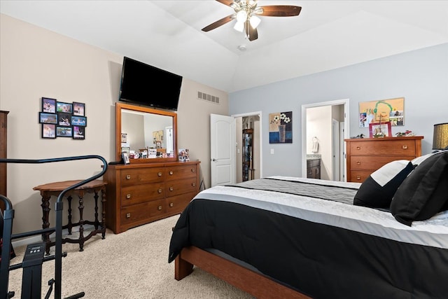 bedroom featuring ceiling fan, lofted ceiling, light carpet, and ensuite bath