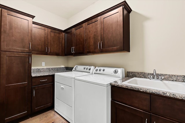 washroom featuring light hardwood / wood-style floors, sink, cabinets, and independent washer and dryer