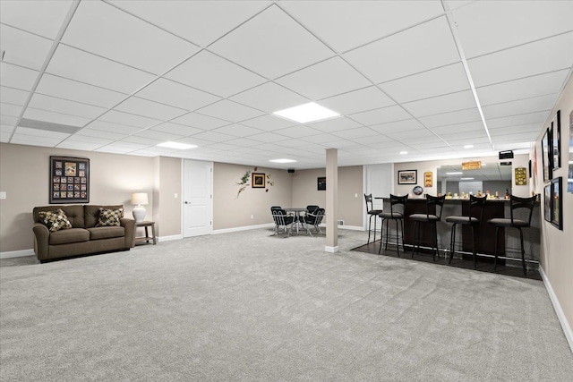 carpeted living room with bar area and a paneled ceiling