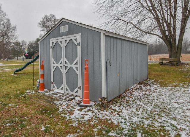 snow covered structure featuring a playground