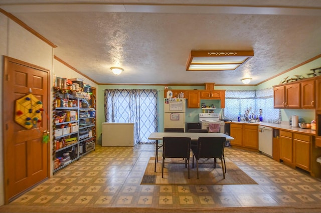 kitchen featuring crown molding, vaulted ceiling, white appliances, a kitchen bar, and a textured ceiling