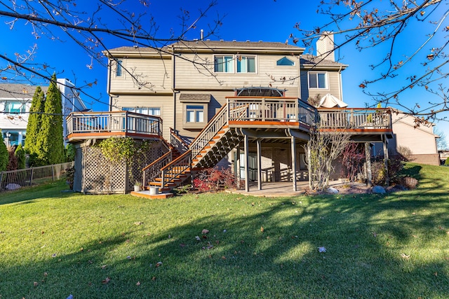 rear view of house featuring a deck, a patio area, and a lawn