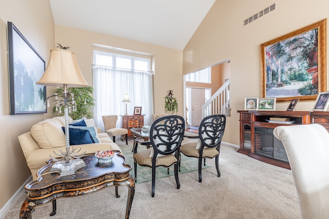 carpeted living room featuring high vaulted ceiling