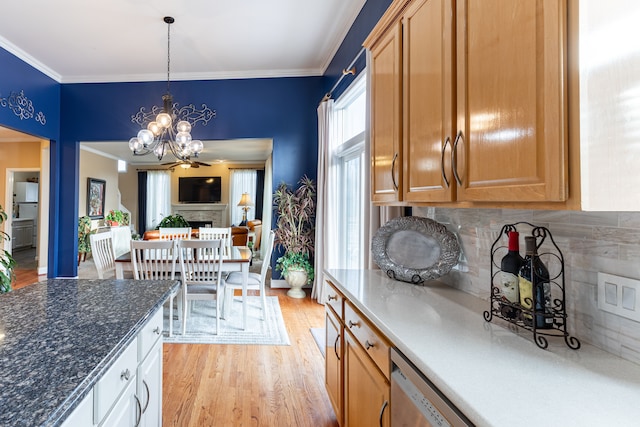 kitchen with hanging light fixtures, light hardwood / wood-style flooring, backsplash, ceiling fan with notable chandelier, and ornamental molding