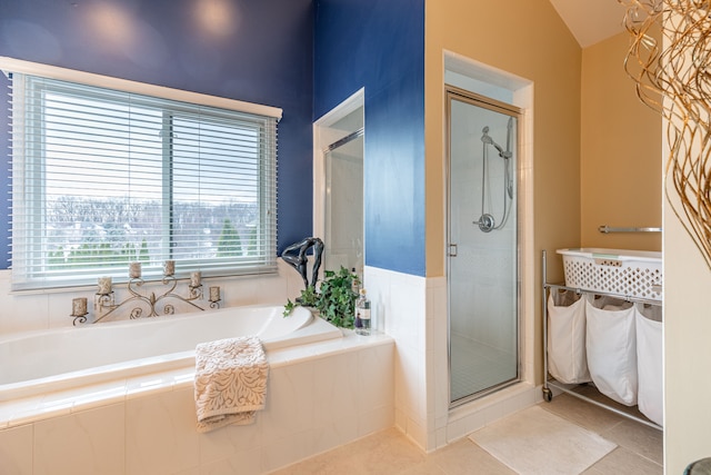 bathroom with tile patterned flooring, vaulted ceiling, and shower with separate bathtub