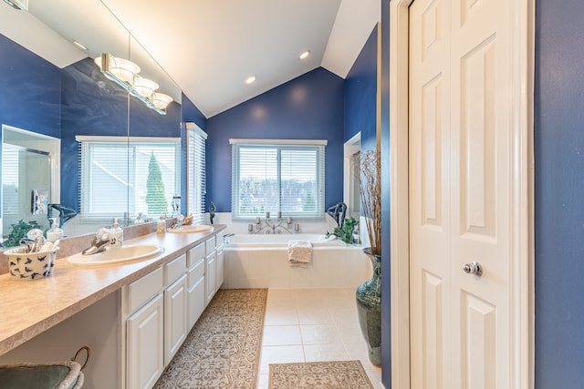 bathroom with tiled tub, tile patterned flooring, vanity, and lofted ceiling