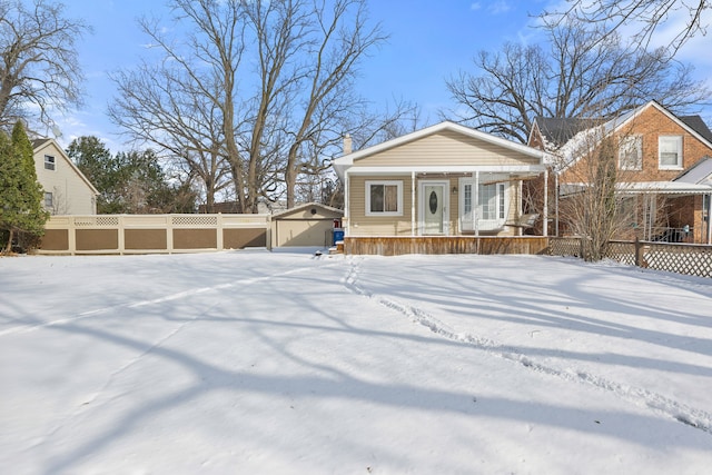 view of front of property with a porch, a garage, and an outdoor structure