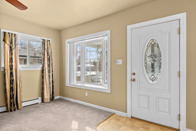 carpeted entrance foyer with ceiling fan and baseboard heating