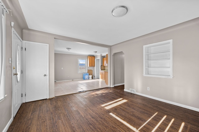 unfurnished living room with hardwood / wood-style flooring and built in features