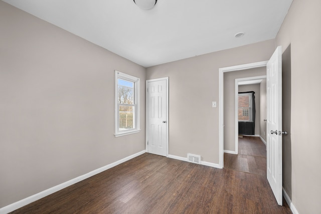 unfurnished bedroom featuring a closet and dark hardwood / wood-style flooring