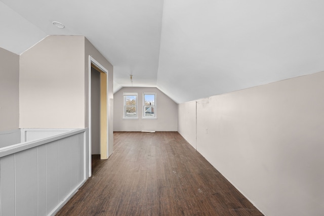 additional living space featuring vaulted ceiling and dark hardwood / wood-style floors