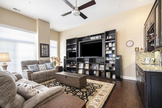 living room with dark hardwood / wood-style flooring, ceiling fan, and sink