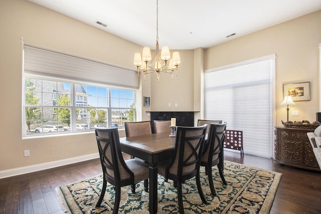 dining room with dark hardwood / wood-style floors and a notable chandelier