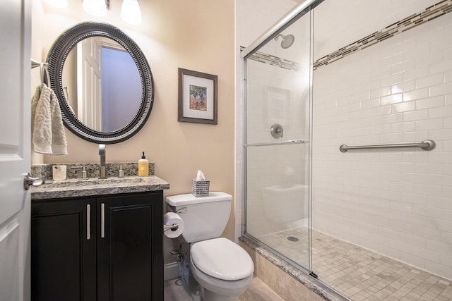 bathroom featuring an enclosed shower, vanity, and toilet