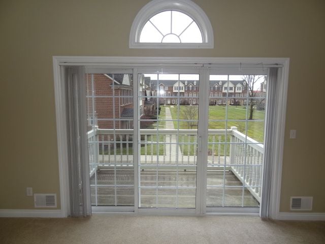 doorway to outside with carpet flooring