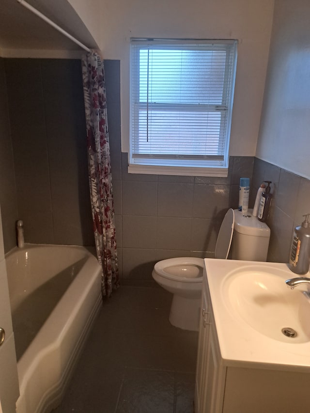 full bathroom featuring shower / tub combo, tile patterned floors, vanity, tile walls, and toilet